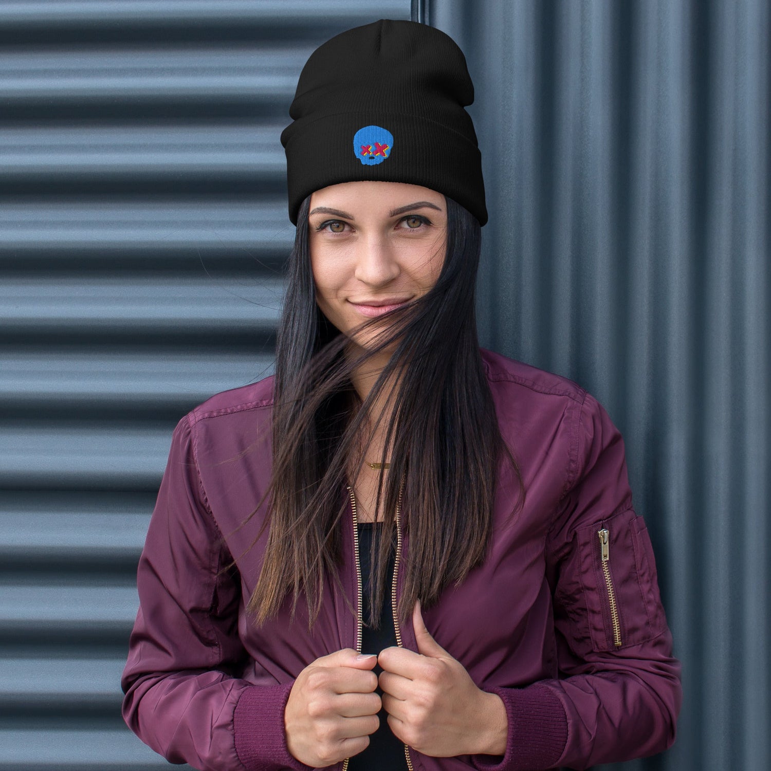 woman wearing a violet bomber jacket and a knitted beanie with an embroidered grunge skull