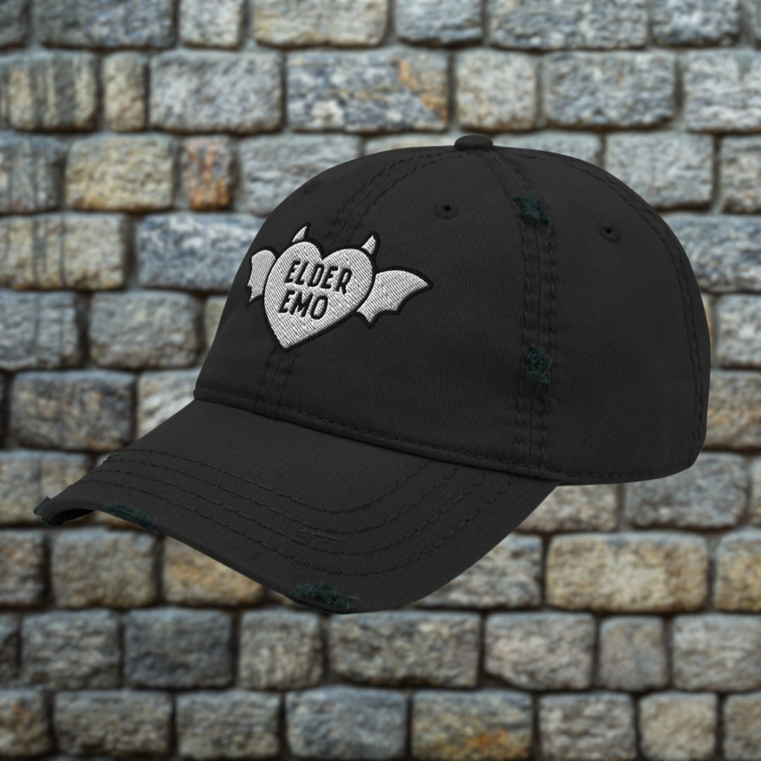 Black distressed otto cap with embroidery "elder emo" and a winged, horned heart
