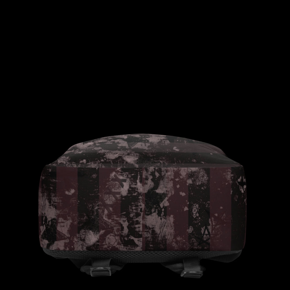 a grunge striped backpack in deep burgundy red and black, with a grungy collage that's visible close-up.