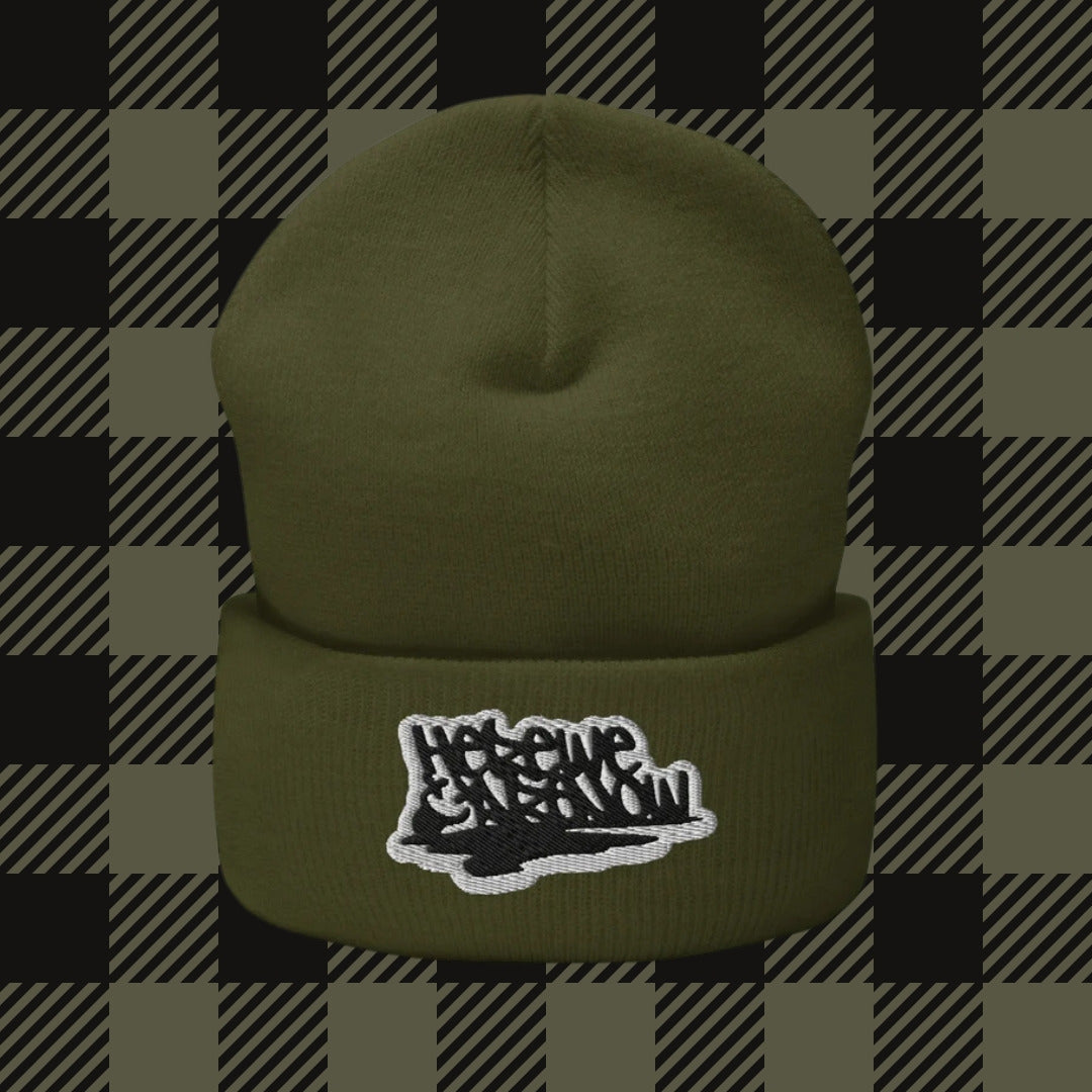 a beanie embroidered with "here we are now" in graffiti tag style