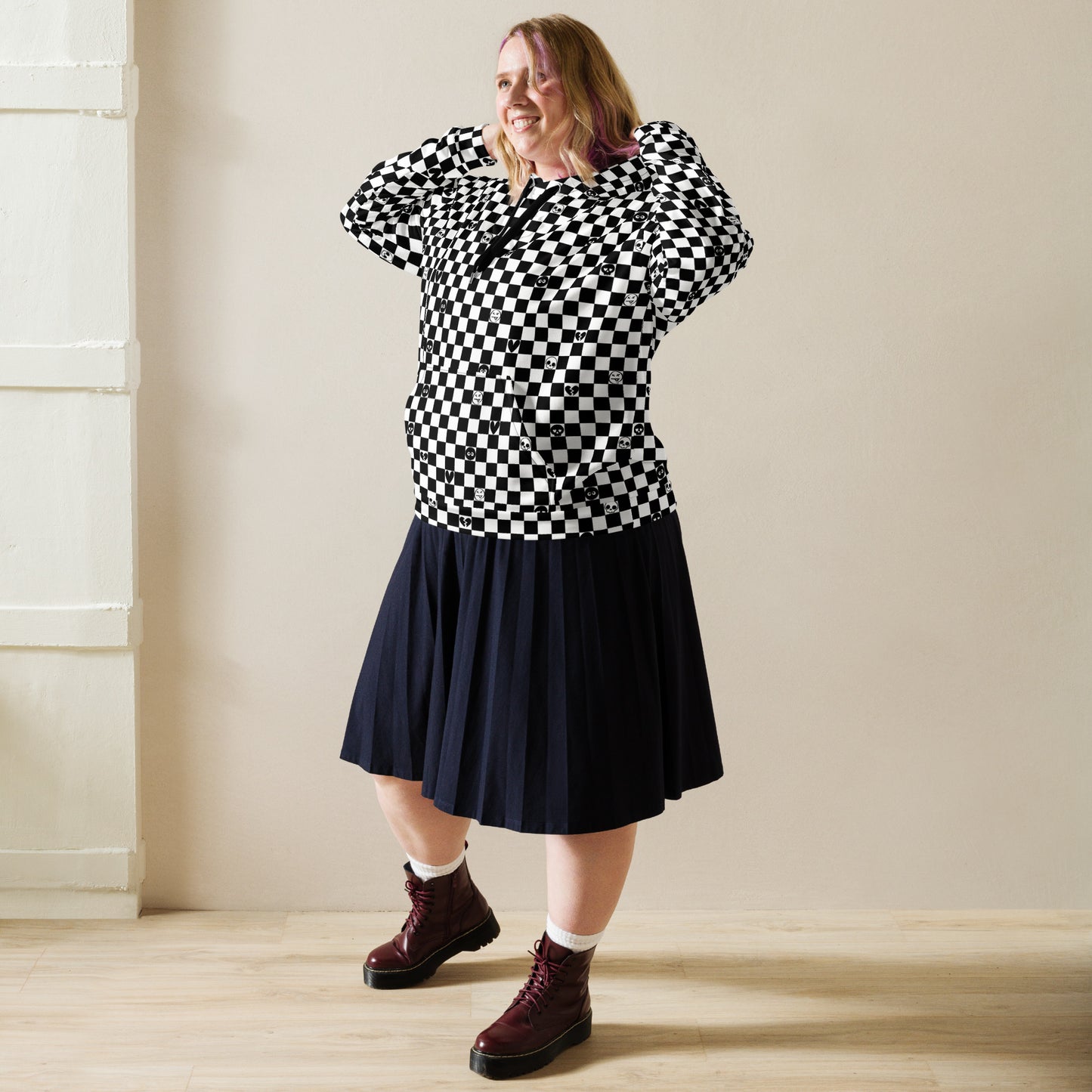 woman with a skirt and boots wearing a black and white checkered hoodie with emo symbols on some square
