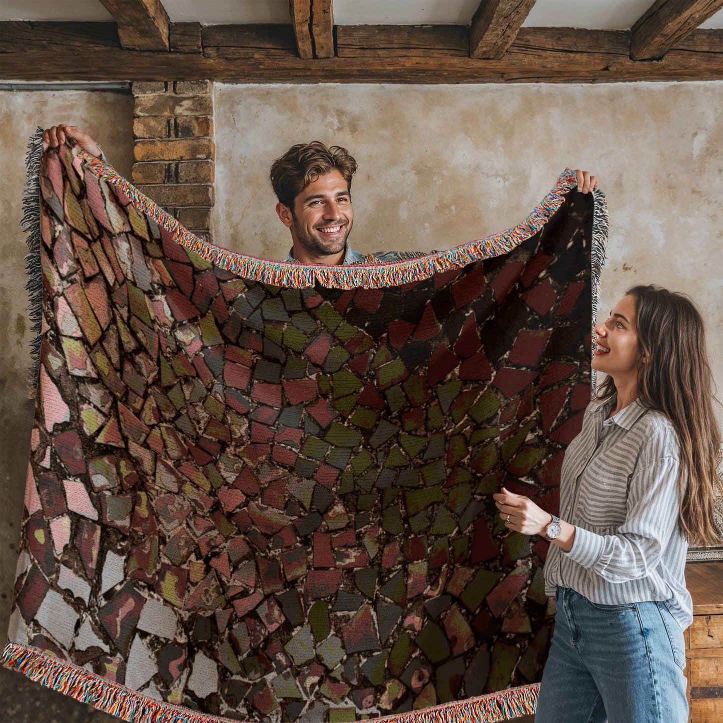 A woven blanket with deep red, black and lighter color shattered mosaic image