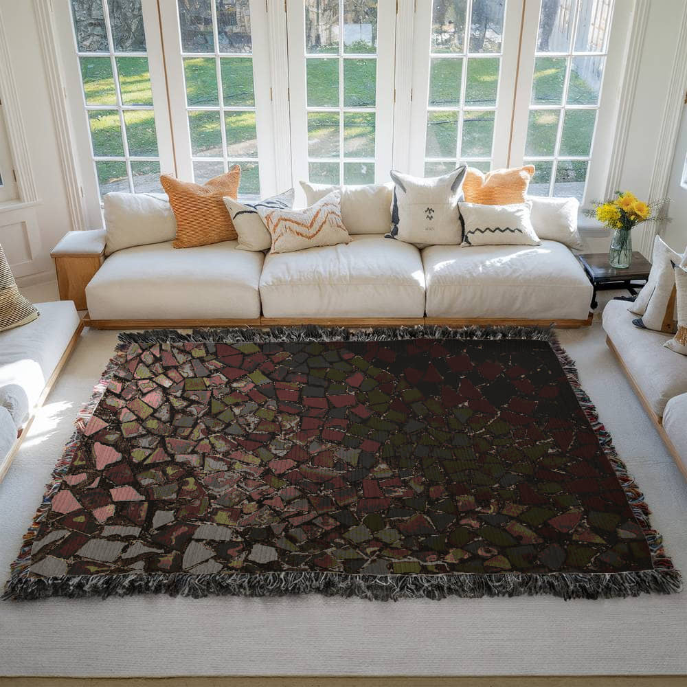 A woven blanket with deep red, black and lighter color shattered mosaic image