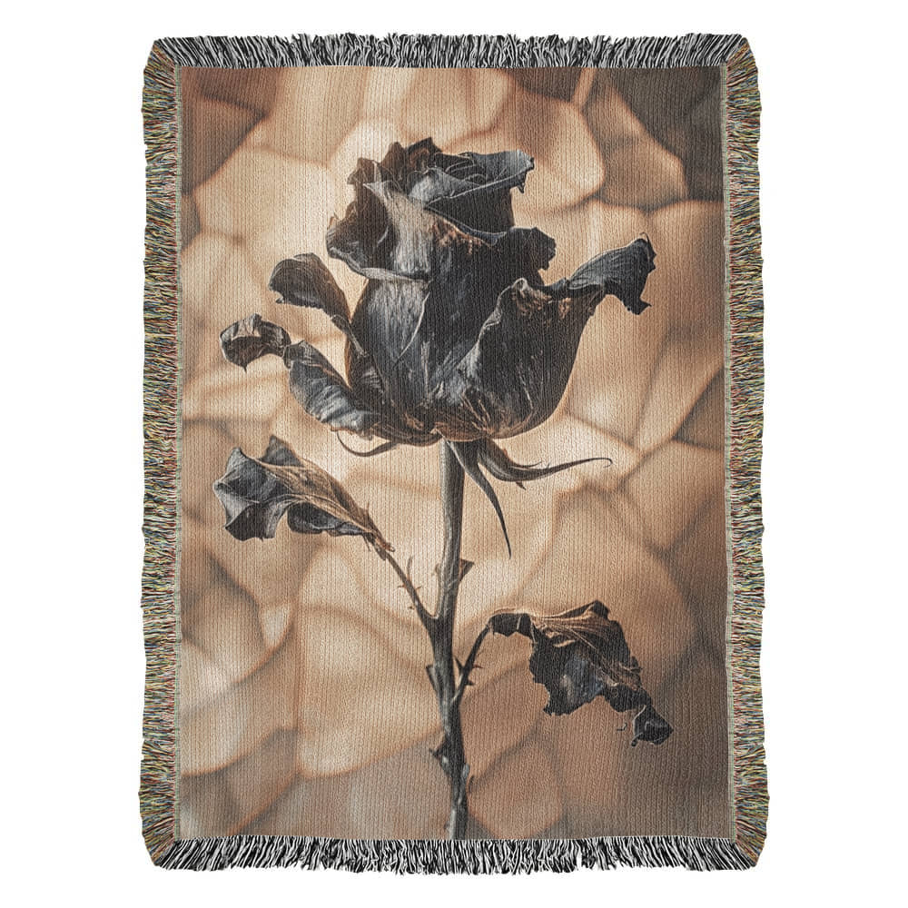 a woven blanket with a black wilted rose and shattered beige background