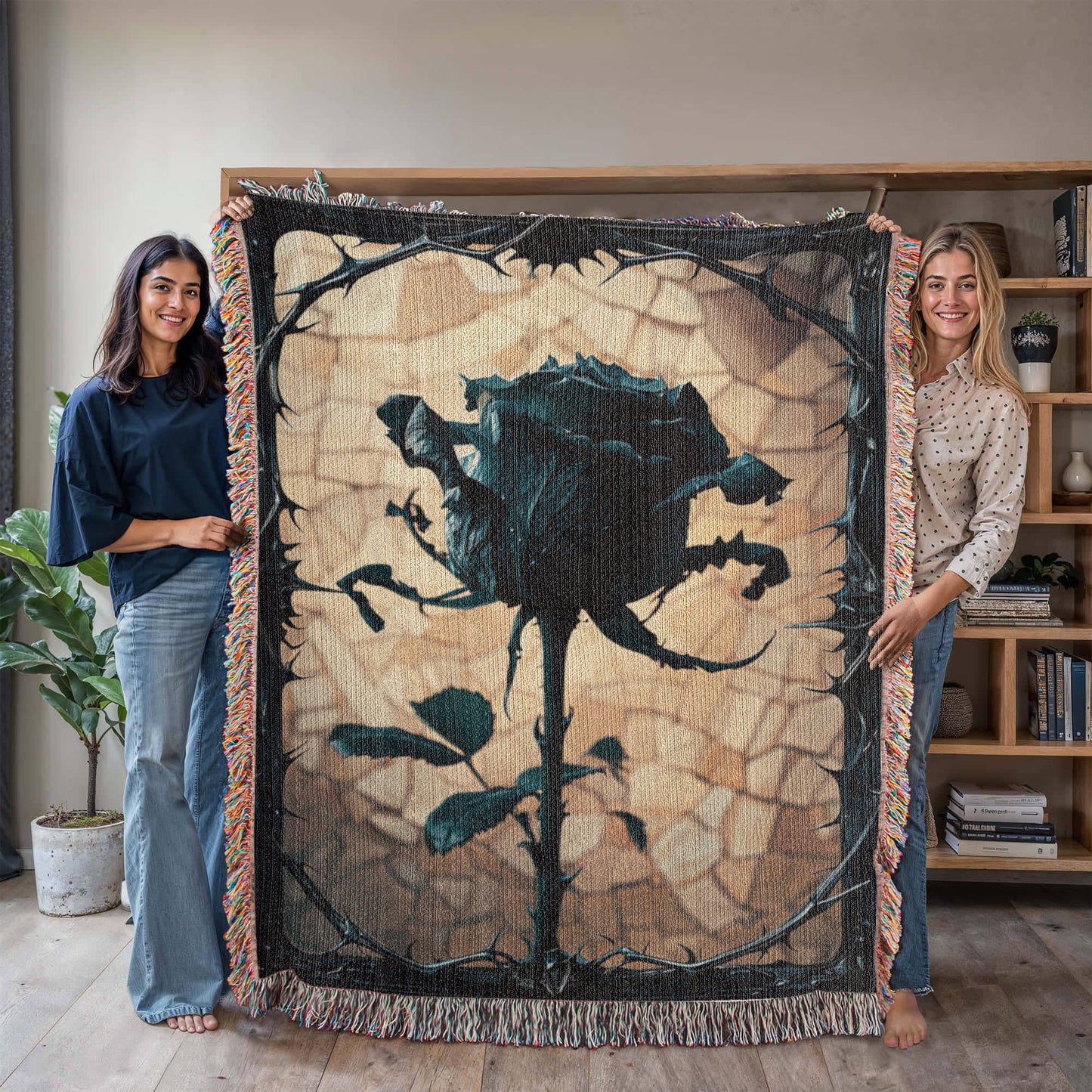 a woven blanket with a black wilted rose and shattered beige background, surrounded by a frame of thorns