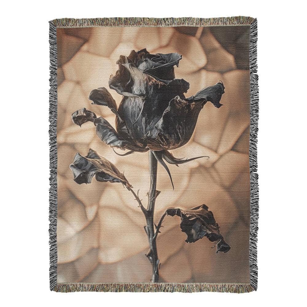 a woven blanket with a black wilted rose and shattered beige background
