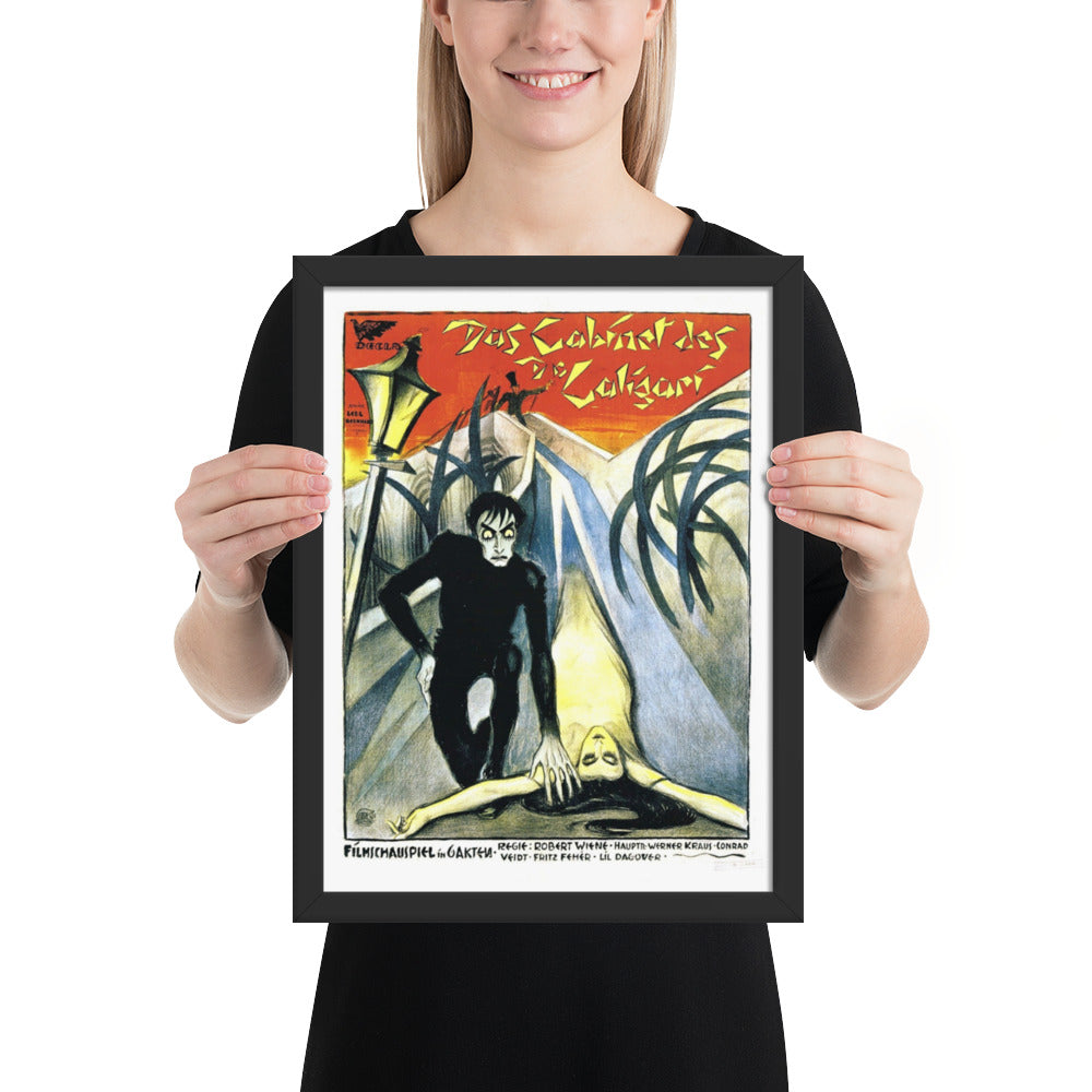 woman holding a framed vintage poster for the movie The Cabinet of Dr. Caligari