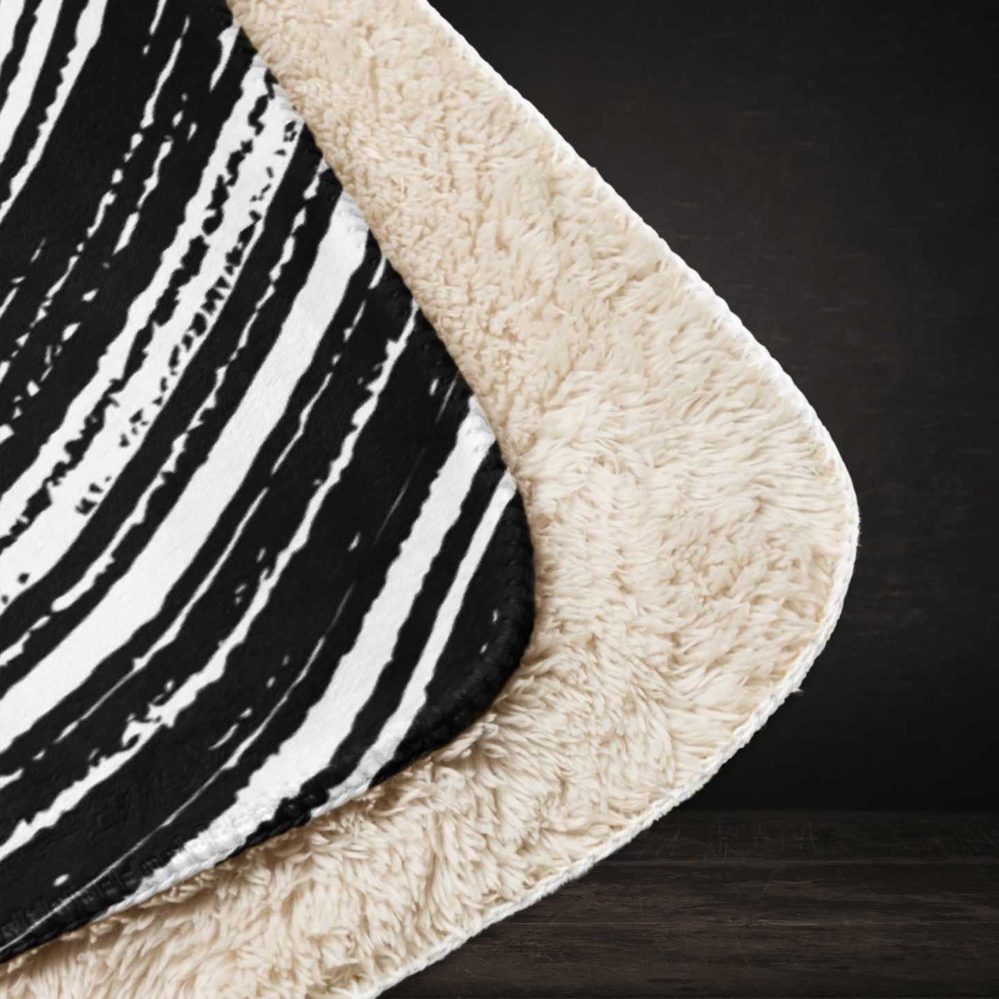 A large sherpa blanket with a black and white drawn vortex and eyeballs floating into it