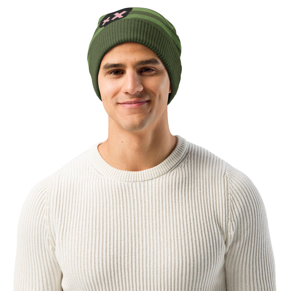 man wearing a green striped beanie with a black skull and pink x-eyes