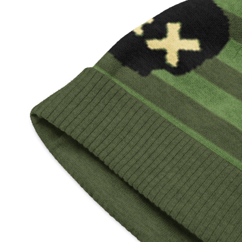 knitted beanie with a black grunge skull with x-eyes on a striped green background