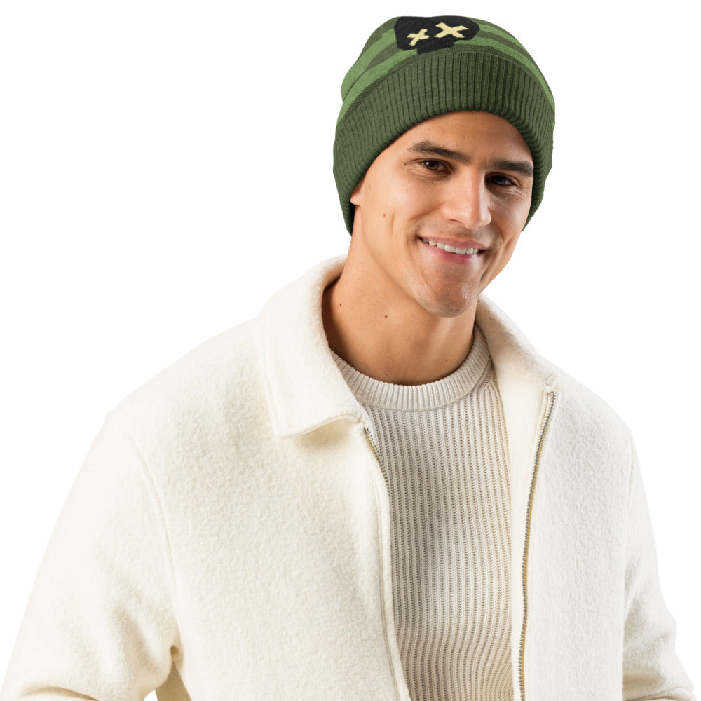 knitted beanie with a black grunge skull with x-eyes on a striped green background