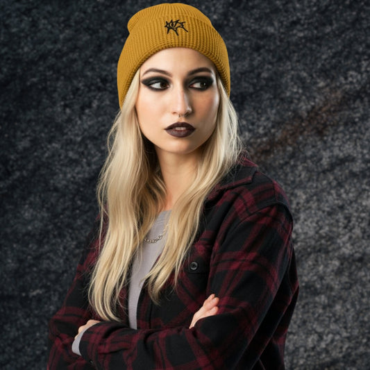 Alt style woman wearing a plaid flannel and a waffle knit beanie with an emo grunge eye embroidery