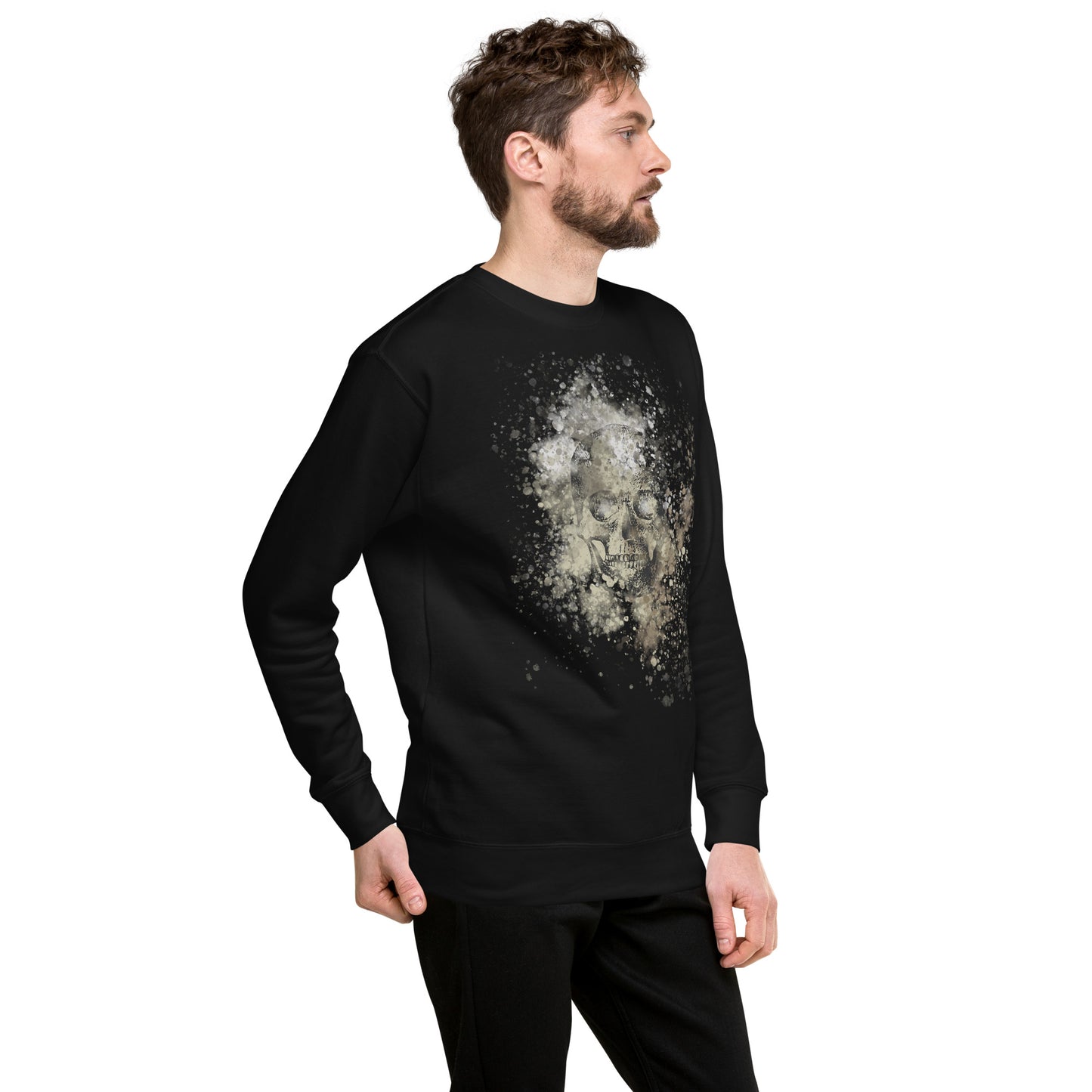 man wearing a sweatshirt with subtle skull graphic surrounded and overlaid with paint splatter in camouflage colors on black
