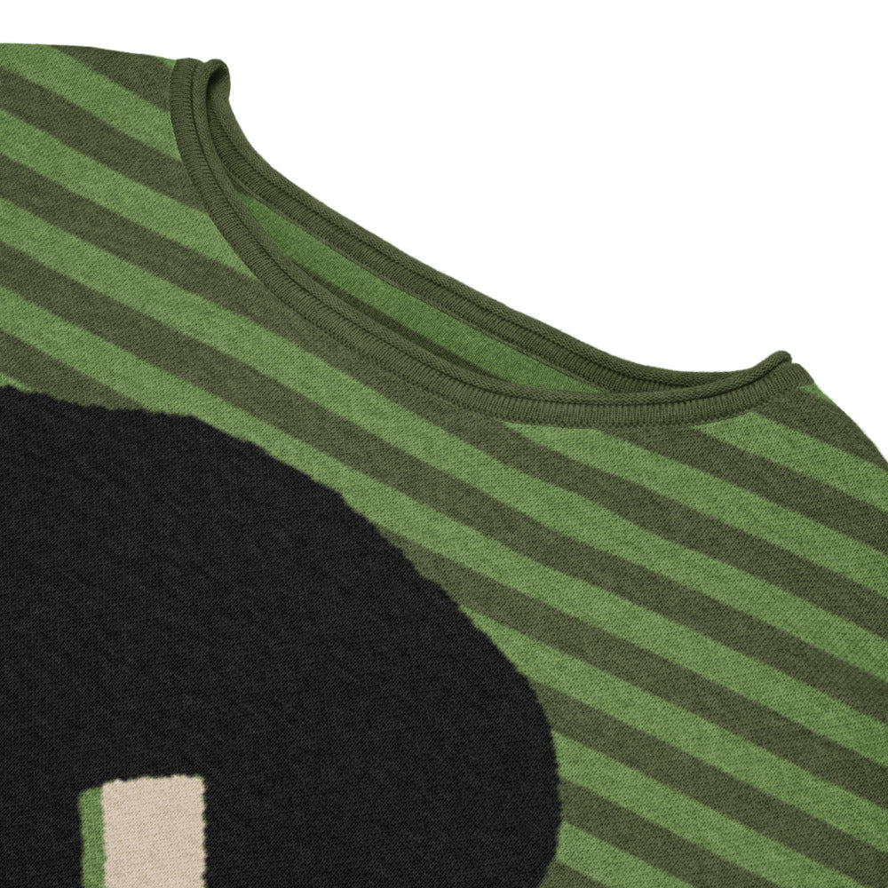 detail of green striped sweater with a large x-eyed skull design