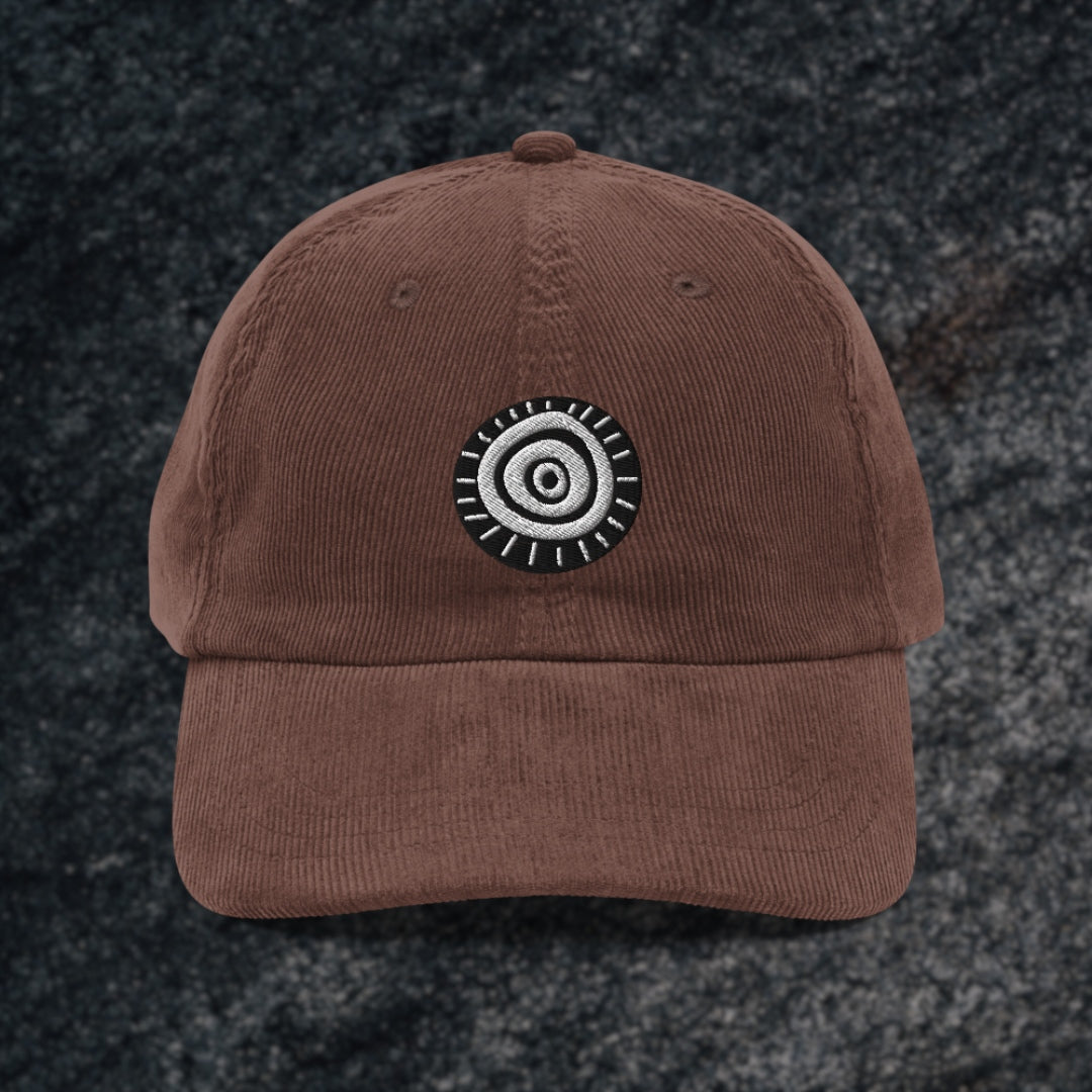 Brown corduroy cap with an embroidered circular stare eye symbol