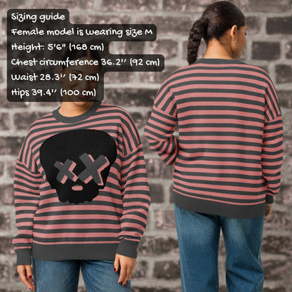 Two people wearing striped knitted sweaters with a skull design, with a sizing guide overlay.