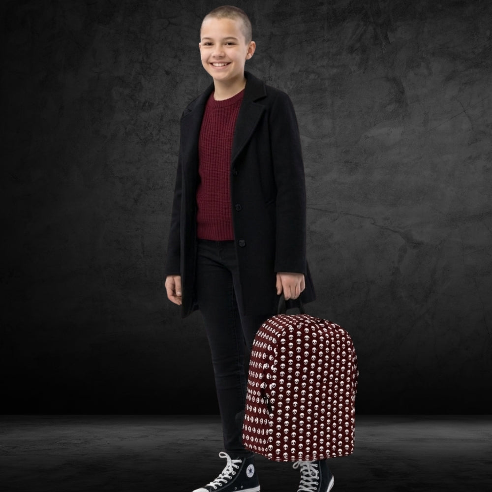 Cool student girl carrying a backpack with a skull pattern on deep red