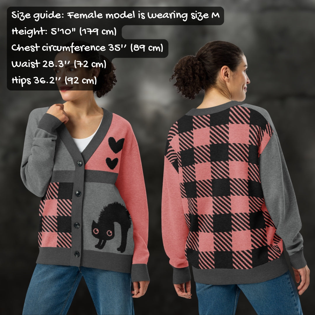 Woman wearing a pink, grey and black knitted cardigan with patchwork pattern areas, with sizing info