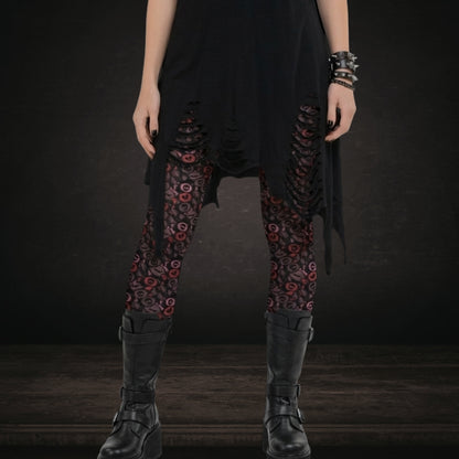 Gothic person wearing leggings with skull and broken heart candy in burgundy pink and red
