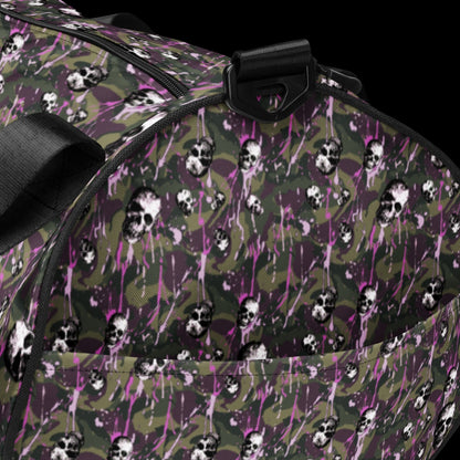 a duffel gym bag with a camo, paint splatter, and gritty skulls pattern in camo and purple shades