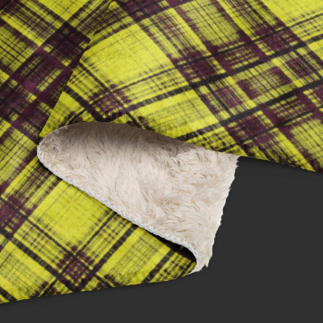 A large fleece sherpa blanket with a distressed burgundy and mustard plaid pattern