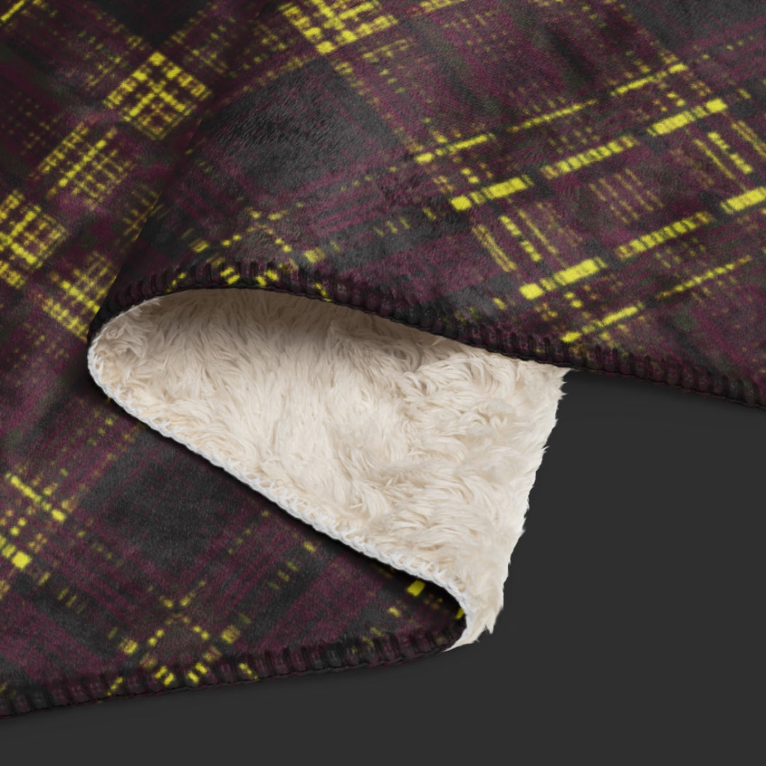A large fleece sherpa blanket with a a deep burgundy and mustard plaid pattern