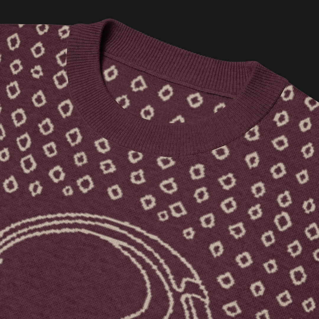 A burgundy short sleeve knit featuring a line art skull with headphones and hand drawn diamonds