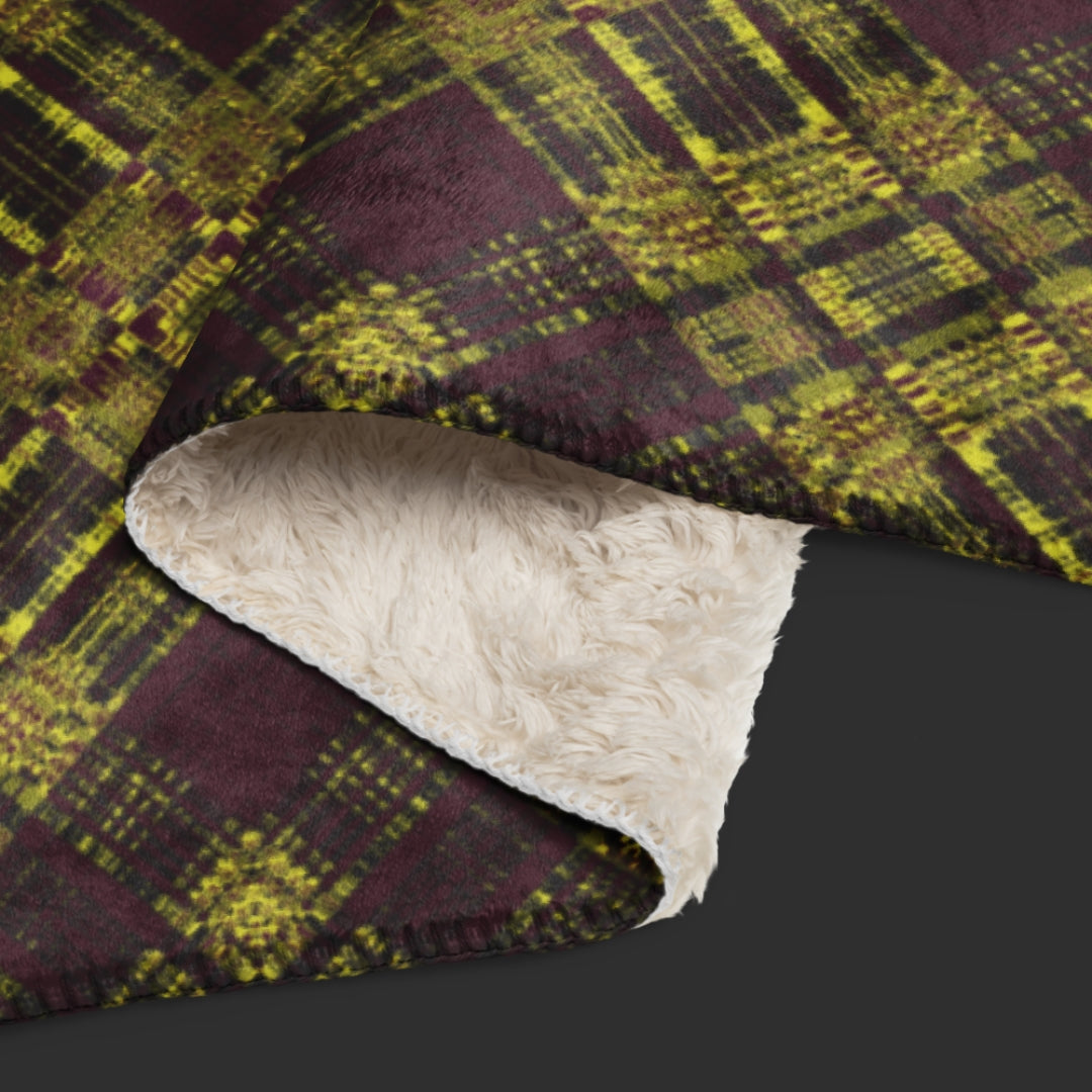 A large fleece sherpa blanket with a a deep burgundy and mustard plaid pattern