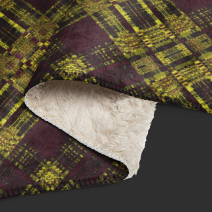 A large fleece sherpa blanket with a a deep burgundy and mustard plaid pattern