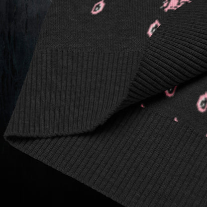 a black knitted vest with crying pink flowers and droplets