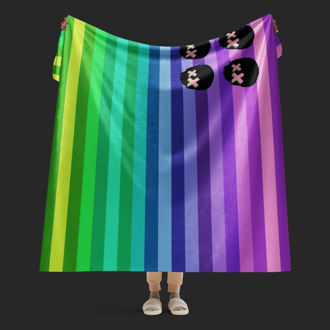 A rainbow colored sherpa blanket featuring skulls and stripes in the format on the American flag