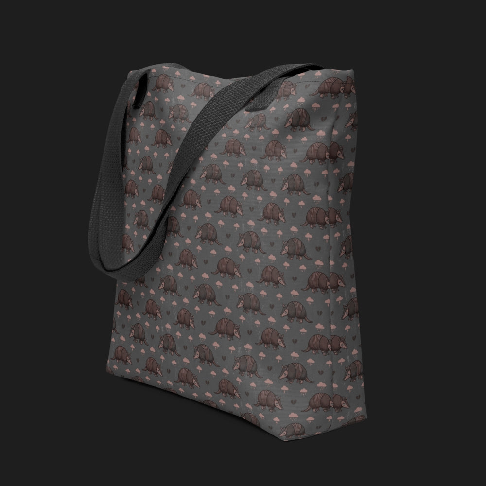 tote bag with an emo armadillo pattern with broken hearts and storm clouds in dusty pink and grey