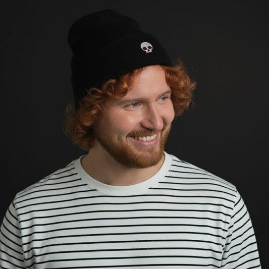 Person wearing a cuffed beanie with a clean minimalistic skull embroidery