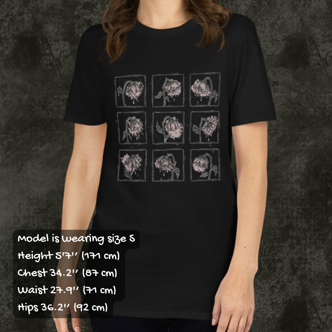 Person wearing a black gildan 64000 tee with a grid of sad crying flowers in soft pink, with sizing info