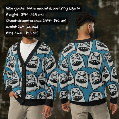 A man wearing an electric blue knitted cardigan with large grey grinning goblins and sizing info.