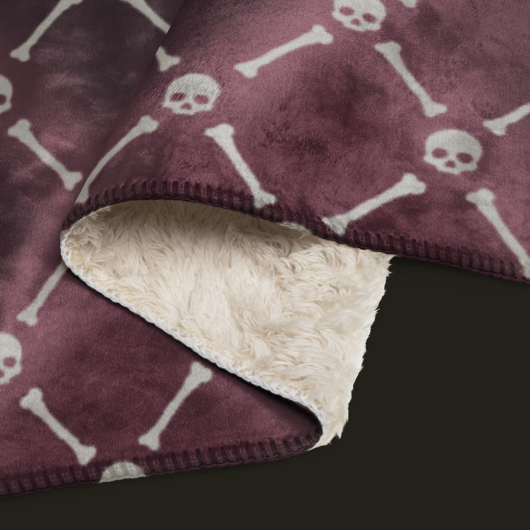 A fleece sherpa blanket with a soft argyle pattern and skulls and bones diagonals