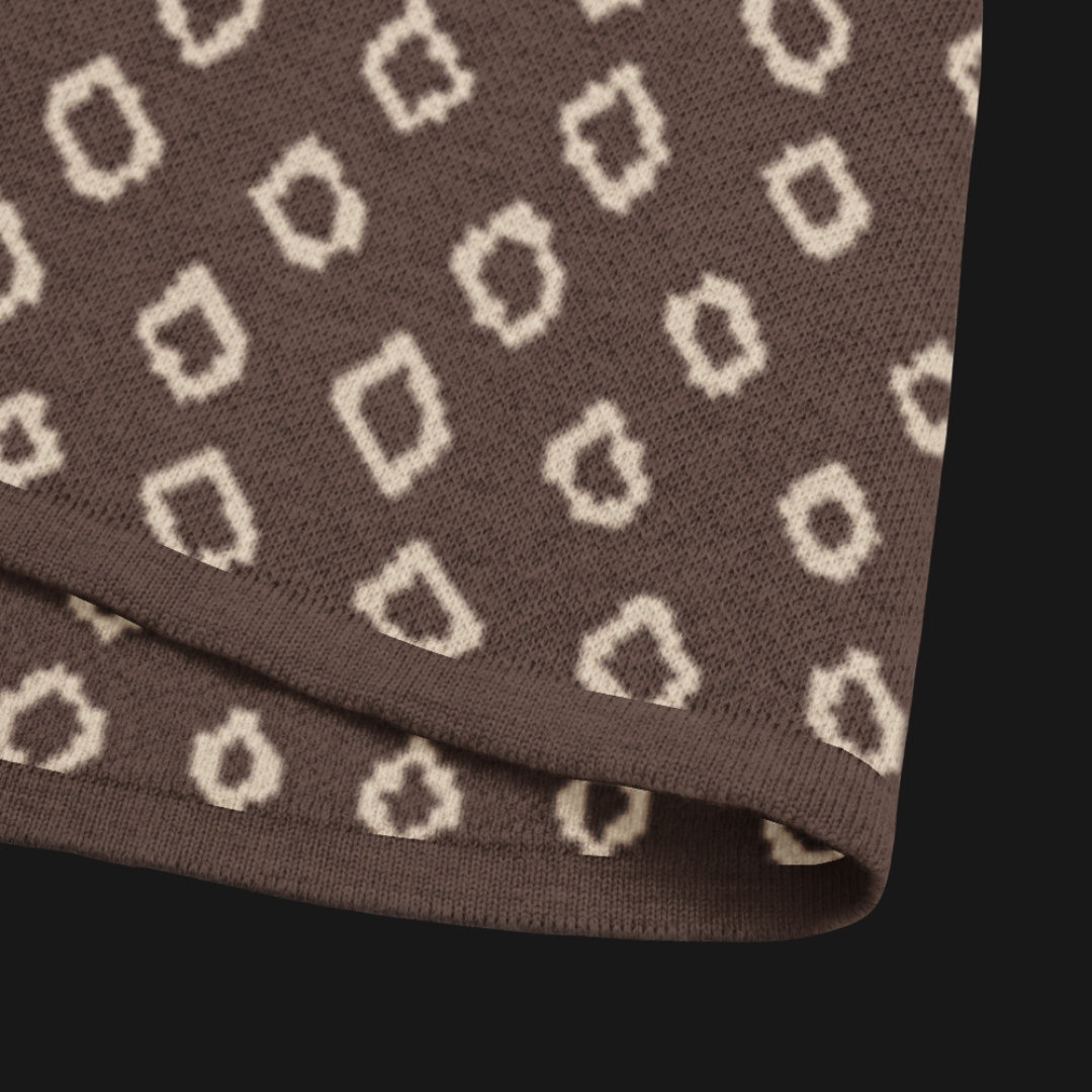 A brown short sleeve knit featuring a line art skull with headphones and hand drawn diamonds