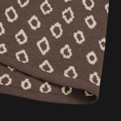 A brown short sleeve knit featuring a line art skull with headphones and hand drawn diamonds