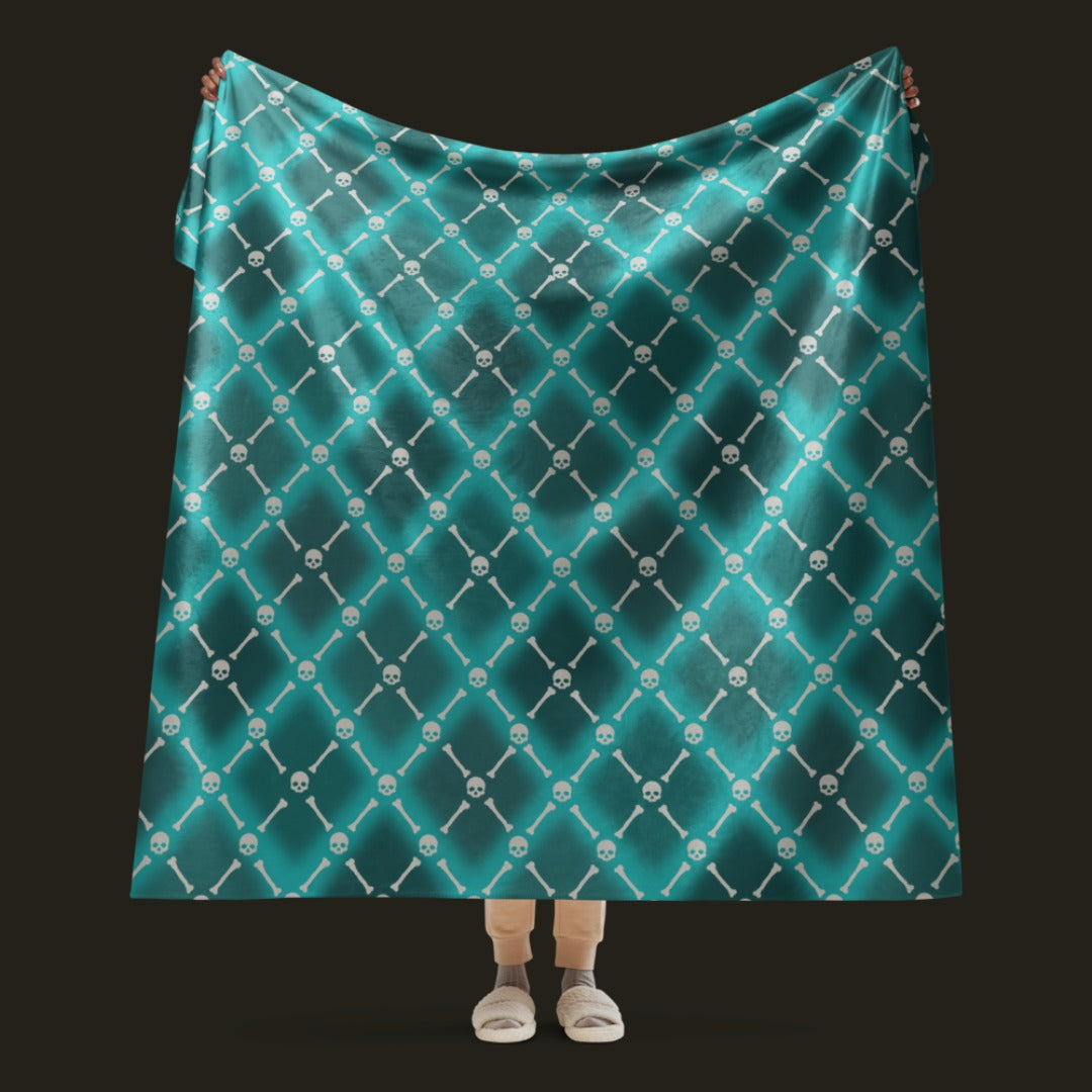 A fleece sherpa blanket with a soft argyle pattern and skulls and bones diagonals