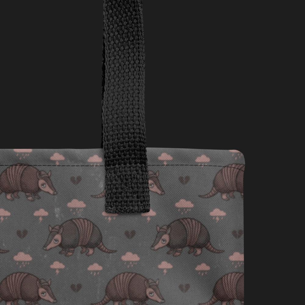 tote bag with an emo armadillo pattern with broken hearts and storm clouds in dusty pink and grey