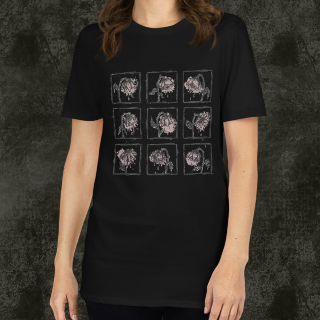 Person wearing a black gildan 64000 tee with a grid of sad crying flowers in soft pink