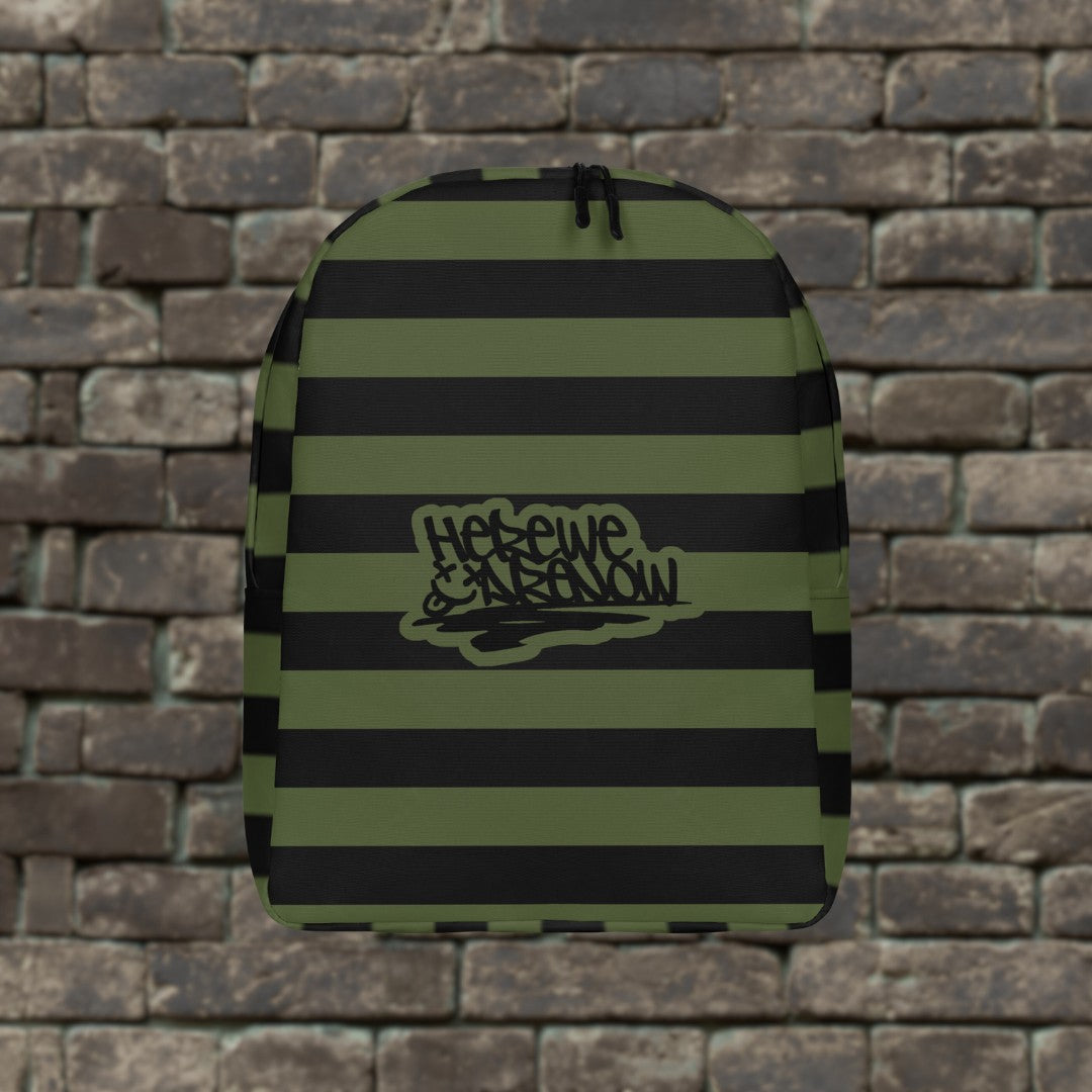 Backpack with green and black grunge style dark stripes and text "here we are now" in graffiti tag style