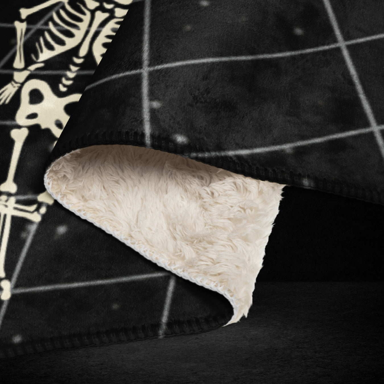 A large sherpa blanket with a vortex grid with skeletons clinging to it, falling and jumping into the void