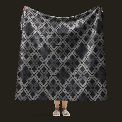 A fleece sherpa blanket with a soft argyle pattern and skulls and bones diagonals
