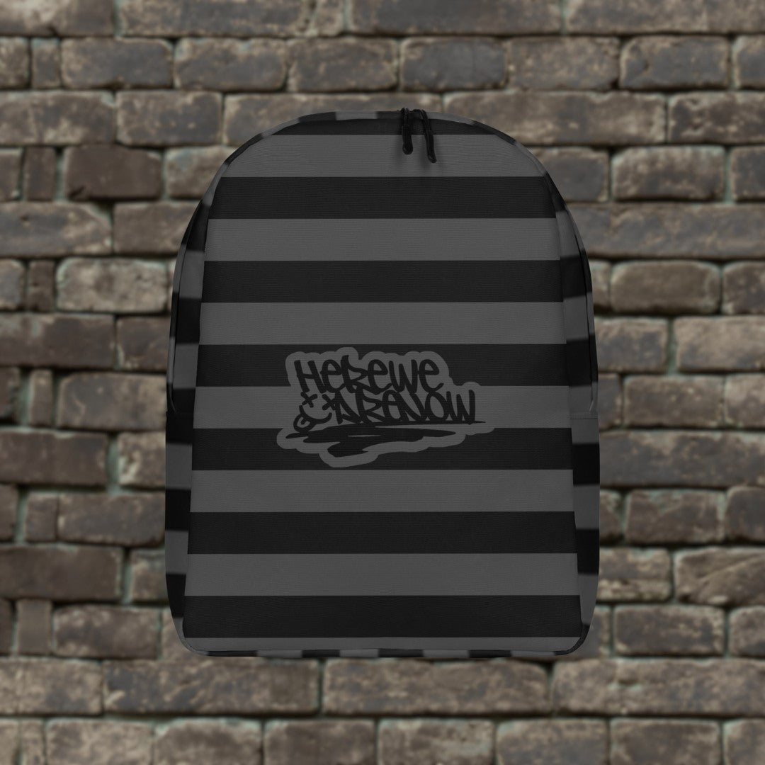 Backpack with grey and black grunge style dark stripes and text "here we are now" in graffiti tag style