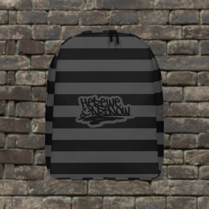 Backpack with grey and black grunge style dark stripes and text "here we are now" in graffiti tag style