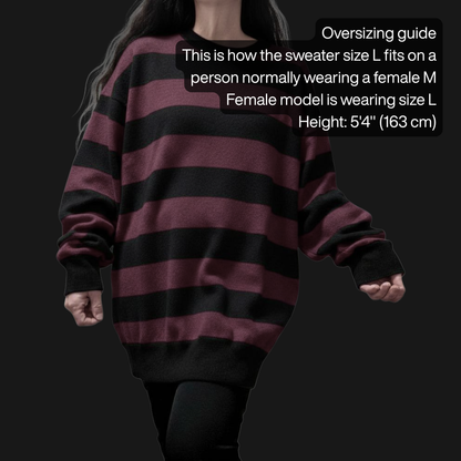 Person wearing an oversized grunge striped sweater with wide black and burgundy stripes