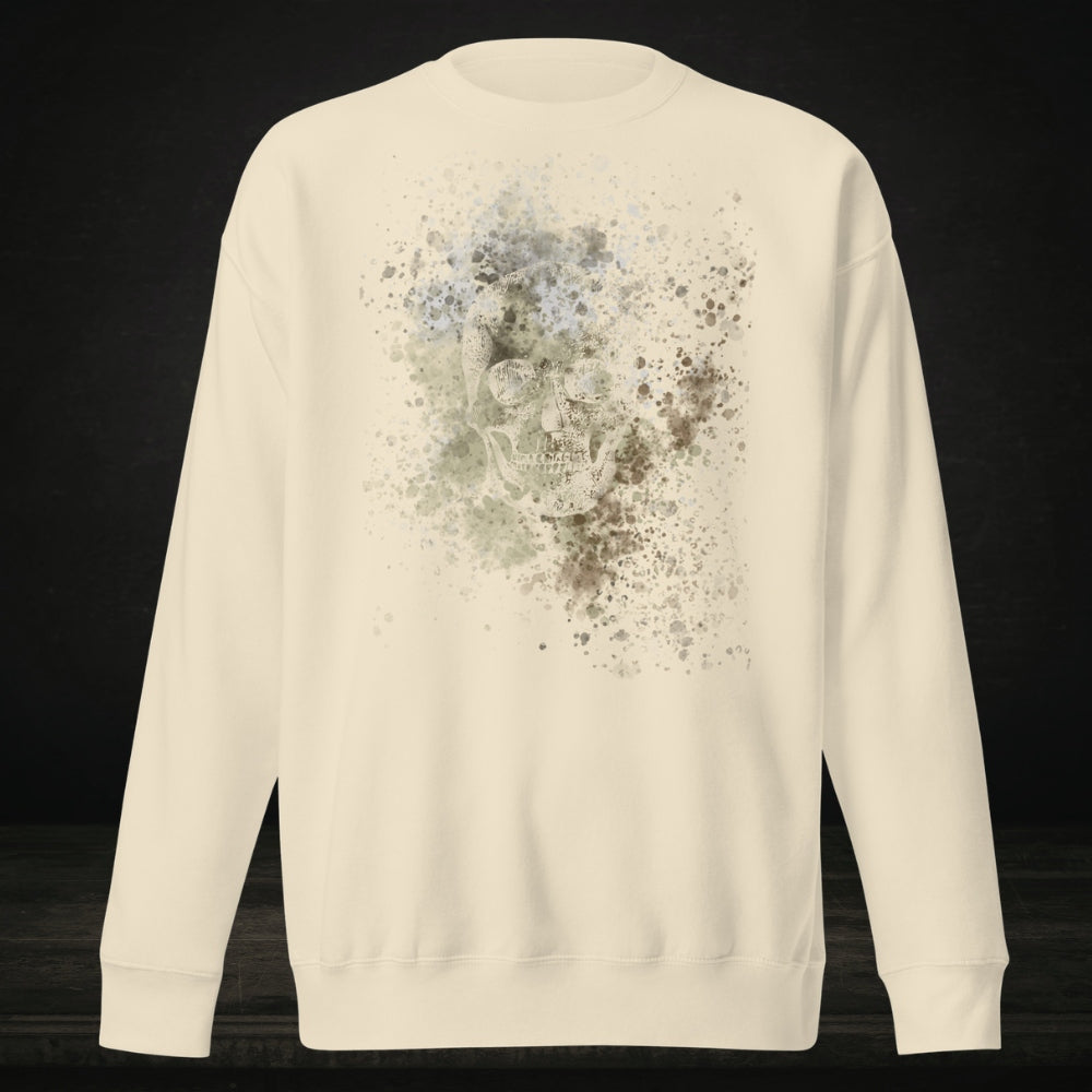 A bone white cotton heritage M2480 sweatshirt with a subtle skull graphic surrounded and overlaid with paint splatter in camouflage colors