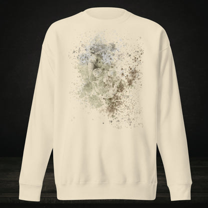 A bone white cotton heritage M2480 sweatshirt with a subtle skull graphic surrounded and overlaid with paint splatter in camouflage colors