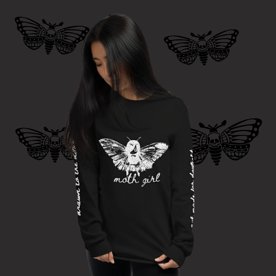 a woman wearing a black long sleeve tee with moth girl print in front and back and text on sleeves